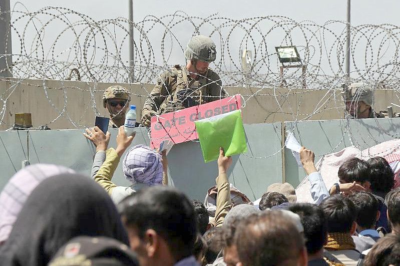 Hunderte Menschen hoffen vor einem Evakuierungskontrollpunkt auf dem Gelände des Flughafens von Kabul darauf, außer Landes zu gelangen. Foto: Wali Sabawoon/AP/dpa