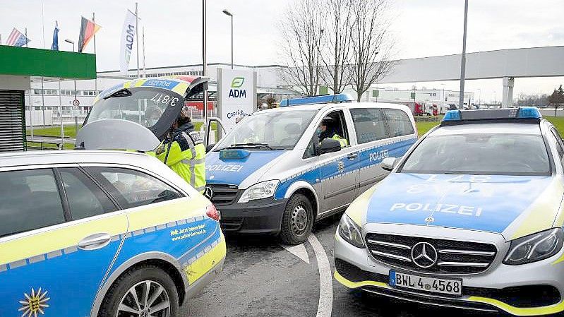 Fahrzeuge der Polizei stehen vor einem Werk eines Getränkeherstellers. Dort hatte eine Serie explosiver Postsendungen begonnen. Foto: Rene Priebe/dpa