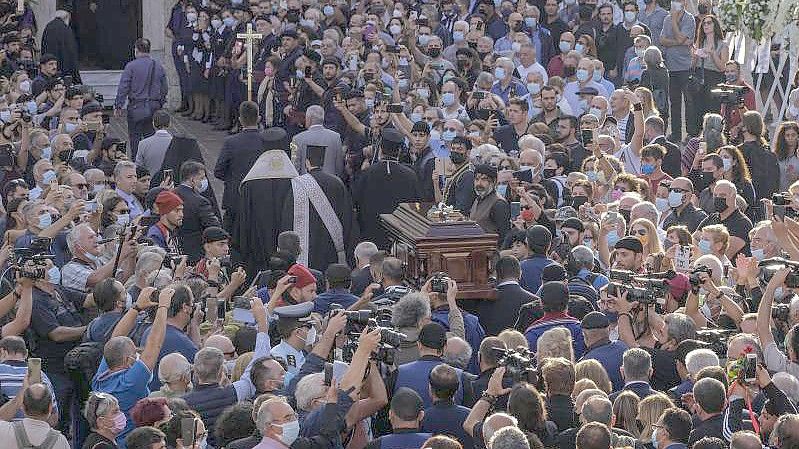 Der Sarg des griechischen Komponisten Mikis Theodorakis wird zur Trauerfeier in die Kirche getragen. Foto: Harry Nakos/AP/dpa