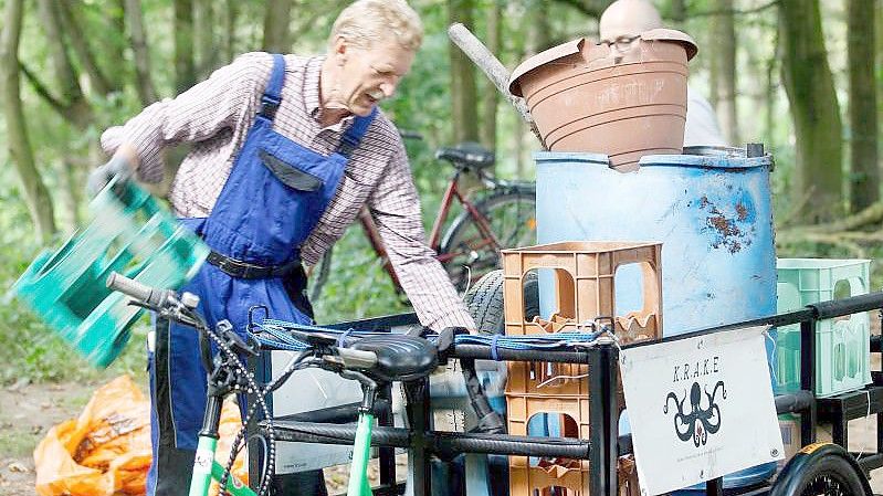 Ein freiwilliger Müllsucher lädt den am Rhein gefundenen Müll auf ein Lastenrad. Rund 50.000 Helfer in sieben europäischen Ländern sollen das Ufer des Rheins und seiner Nebenflüsse säubern. Foto: Roland Weihrauch/dpa