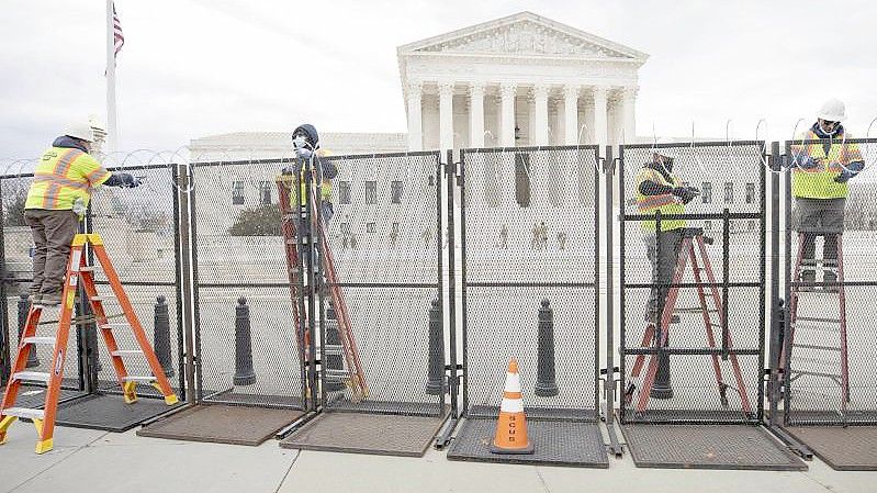 Arbeiter stehen am Sicherheitszaun vor dem US-Kapitol (Archivfoto vom 22. Januar). Foto: Mark Finkenstaedt/ZUMA Wire/dpa