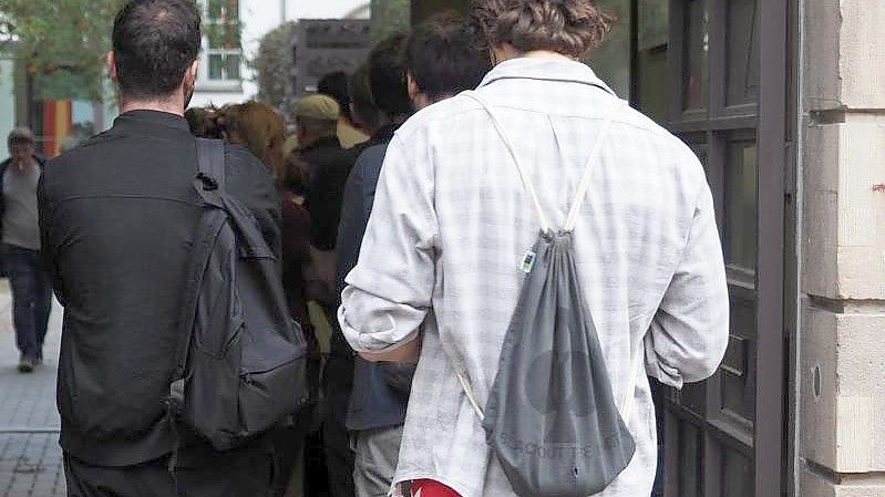 Wahlberechtigte warten deutlich nach 18 Uhr in einer Schlange vor einem Wahllokal an der Mandelstraße im Berliner Stadtteil Prenzlauer Berg darauf, ihre Stimmen abgeben zu dürfen. Foto: Georg Hilgemann/dpa-Zentralbild/dpa