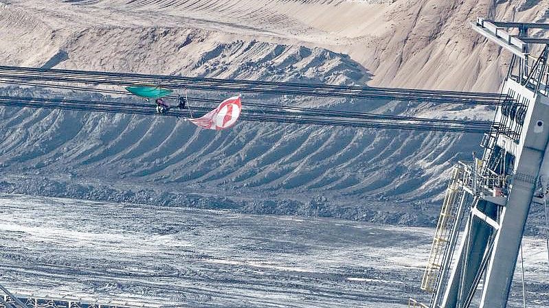 Eine Fahne und Ausrüstungsgegenstände hängen in den Seilen eines Absetzers im Braunkohletagebau Garzweiler II. Foto: Henning Kaiser/dpa