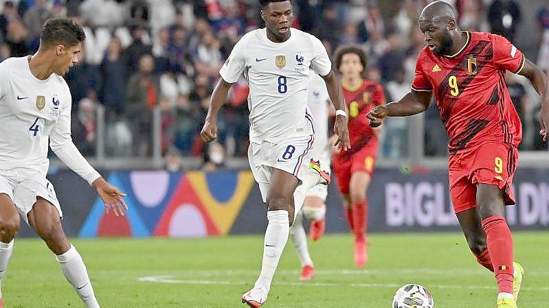 Frankreichs Aurelien Tchouameni (M) und Belgiens Romelu Lukaku (r) kämpfen um den Ball. Foto: Dirk Waem/BELGA/dpa