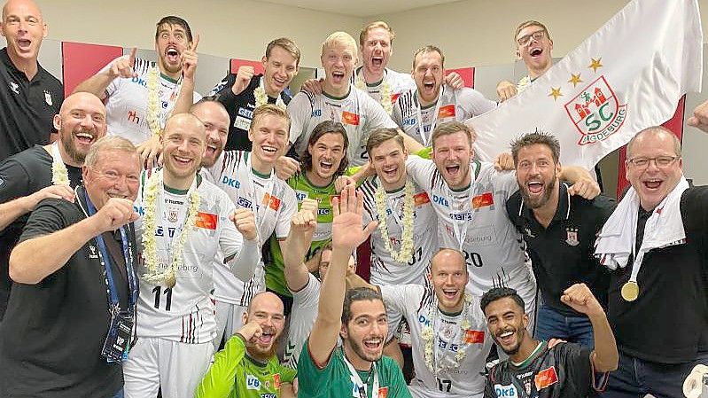 Die Mannschaft des SC Magdeburg jubelt über den Sieg im Finale des IHF Super Globe in Saudi Arabien gegen den FC Barcelona. Foto: -/SC Magdeburg/dpa