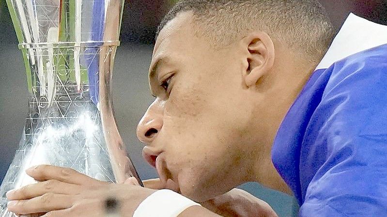 Frankreichs Kylian Mbappé küsst den Pokal. Foto: Luca Bruno/AP/dpa