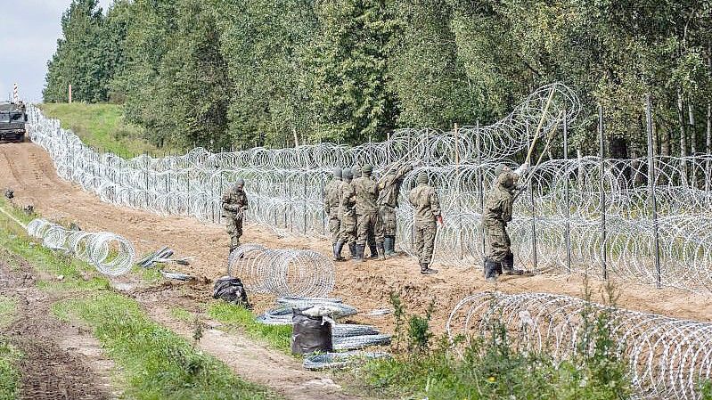 Polnische Soldaten errichten einen Stacheldrahtzaun entlang der Grenze zu Belarus. Immer häufiger kommen Migranten aus Krisengebieten über Belarus illegal nach Polen. Foto: Attila Husejnow/SOPA Images via ZUMA Press Wire/dpa