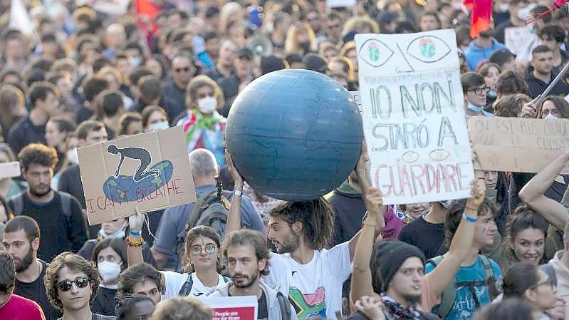 Demonstrierende halten Protestschilder zum Auftakt des G20-Gipfels. Die Bemühungen um ein starkes Signal im Klimaschutz drohen zu scheitern. Foto: Luca Bruno/AP/dpa