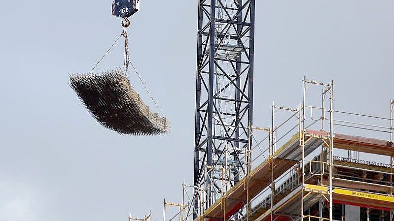 An einem Baukran wird Baumaterial auf der Baustelle des Quartiers Heidestrasse in Berlin transportiert. Foto: Carsten Koall/dpa