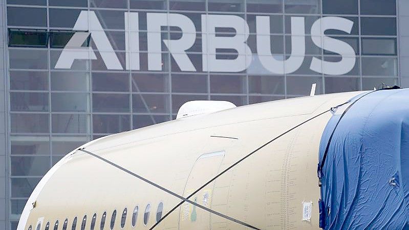 Das Segment eines Flugzeugrumpfes eines Airbus A350 steht vor einer Fertigungshalle auf dem Werksgelände des Flugzeugbauers Airbus in Hamburg. Foto: Marcus Brandt/dpa