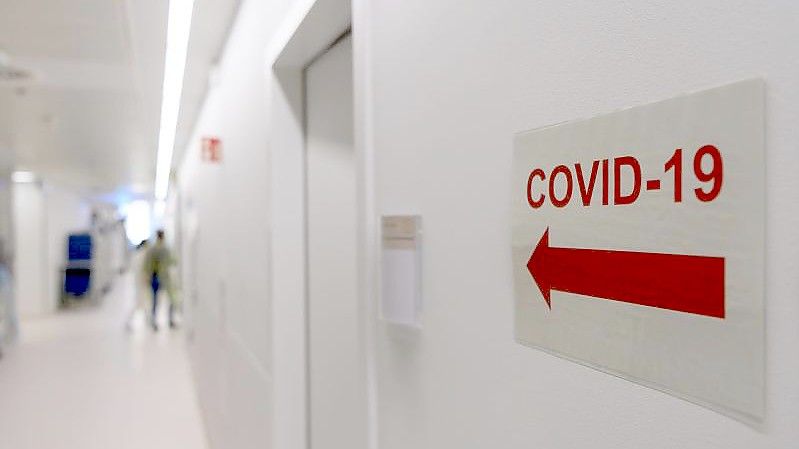 Ein Schild weist in einer Klinik den Weg zur Corona-Intensivstation. Foto: Robert Michael/dpa-Zentralbild/dpa