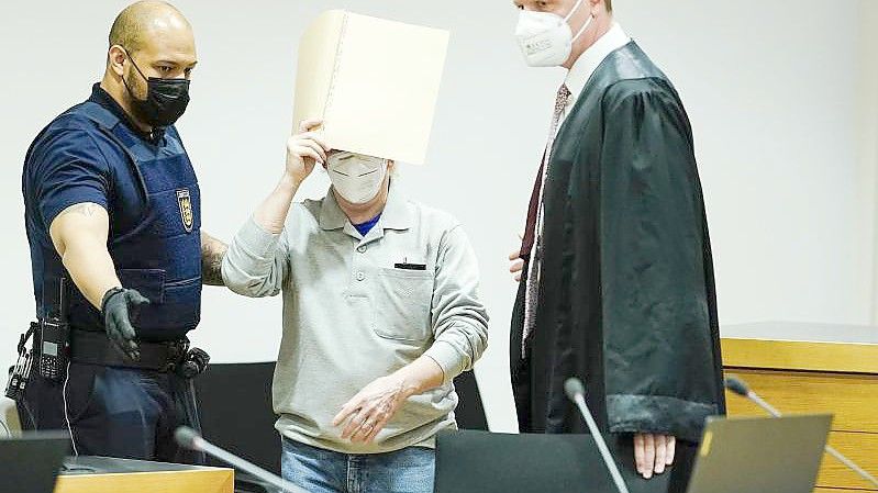 Der Angeklagte (M) mit seinem Anwalt Steffen Lindberg (r) und einem Justizbeamten zu Prozessbeginn im September im Gericht. Foto: Uwe Anspach/dpa-pool/dpa