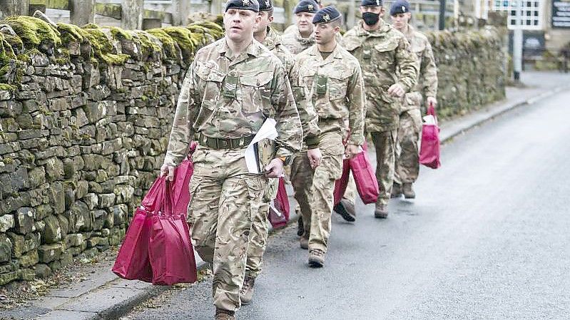 Angehörige der Streitkräfte tragen Versorgungspakete, um sie an Betroffene im britischen St. John's Chapel zu verteilen. Foto: Danny Lawson/PA Wire/dpa