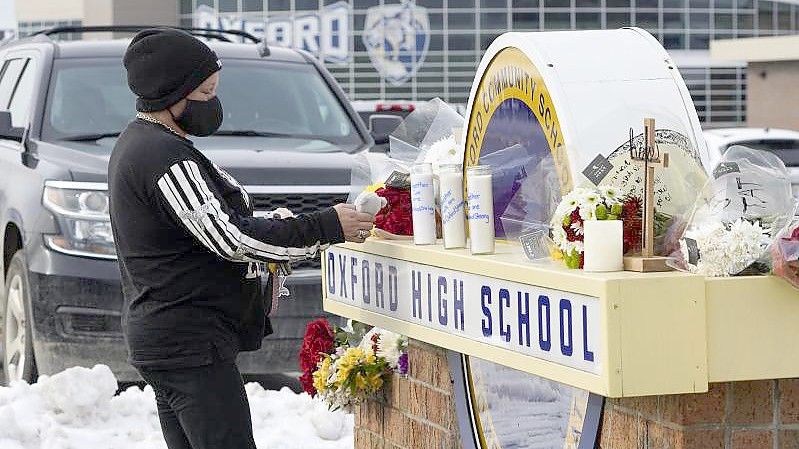 Eine Frau hinterlässt am Schild der Oxford High School ein Plüschtier. Foto: Paul Sancya/AP/dpa