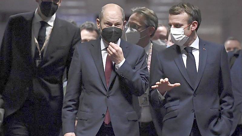 Bundeskanzler Olaf Scholz (M) und Frankreichs Präsident Emmanuel Macron (r) vor der abschließenden Pressekonferenz des EU-Gipfels. Foto: John Thys/Pool AFP/dpa