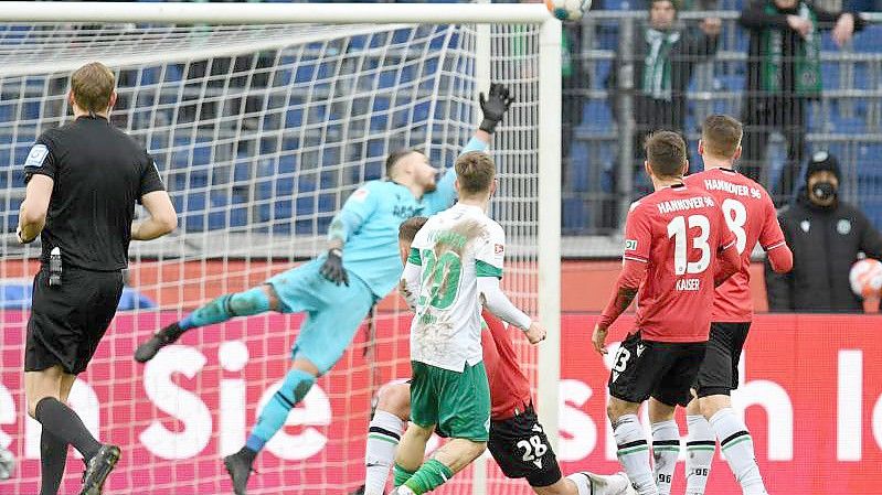 Romano Schmid (M) trifft zur Bremer Führung, Hannovers Torwart Martin Hansen kann den Ball nicht abwehren. Foto: Daniel Reinhardt/dpa