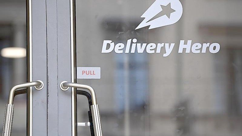 Das Logo von Delivery Hero ist an einer Glasscheibe angebracht. Foto: Britta Pedersen/dpa-Zentralbild/dpa/Archivbild