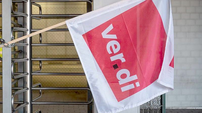 Eine Verdi-Fahne ist während eines Warnstreiks der Flugzeugabfertiger der Wisag am Flughafen Frankfurt an einen Eingang gekettet. Foto: Sebastian Christoph Gollnow/dpa
