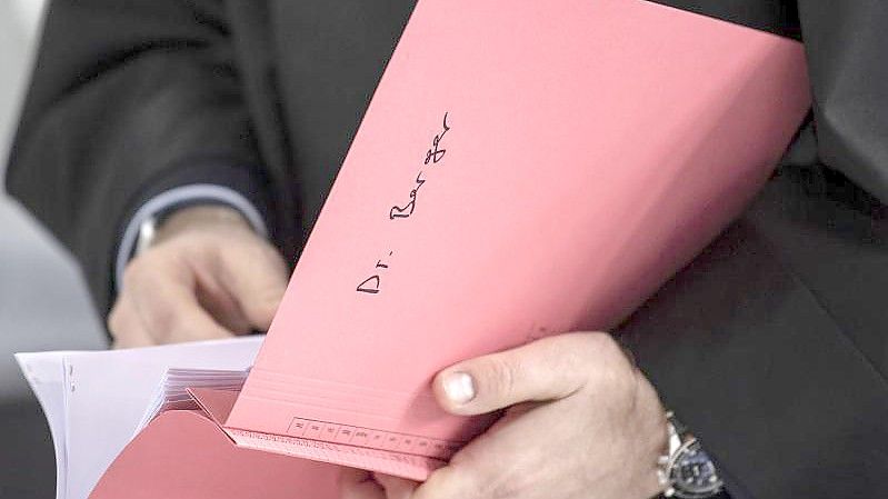 Ein Rechtsanwalt von Hanno Berger hält vor dem Prozessauftakt um „Cum-Ex“-Aktiendeals dessen Akte in der Hand. Foto: Boris Roessler/dpa