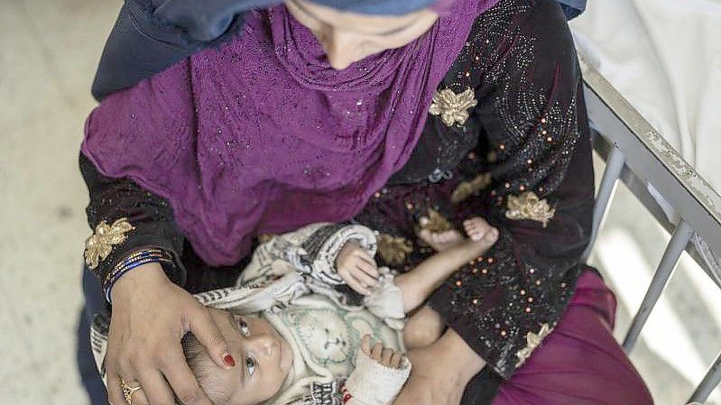 Eine Mutter mit ihrem vier Monate alten Baby auf einer Station für Unterernährung in Afghanistans Haupstadt Kabul. Foto: Petros Giannakouris/AP/dpa