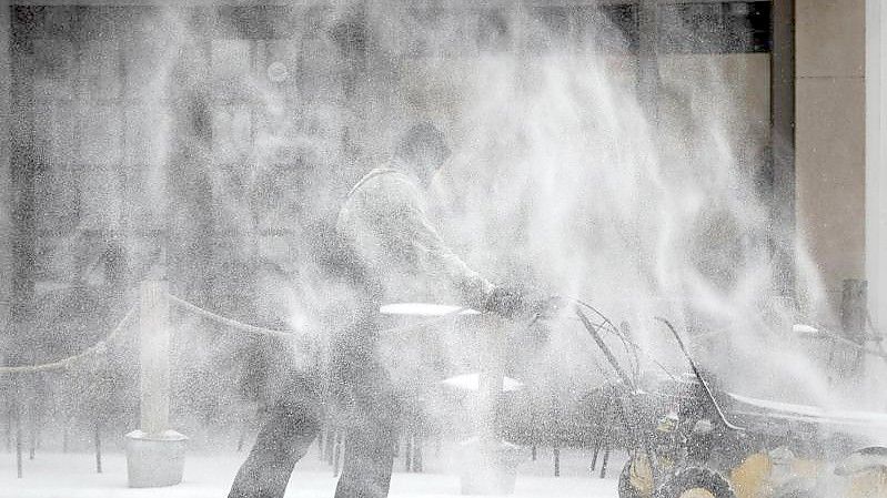 Ein Mann räumt Schnee auf dem Fußweg entlang der Fifth Street in Winston-Salem. Foto: Allison Lee Isley/The Winston-Salem Journal/dpa