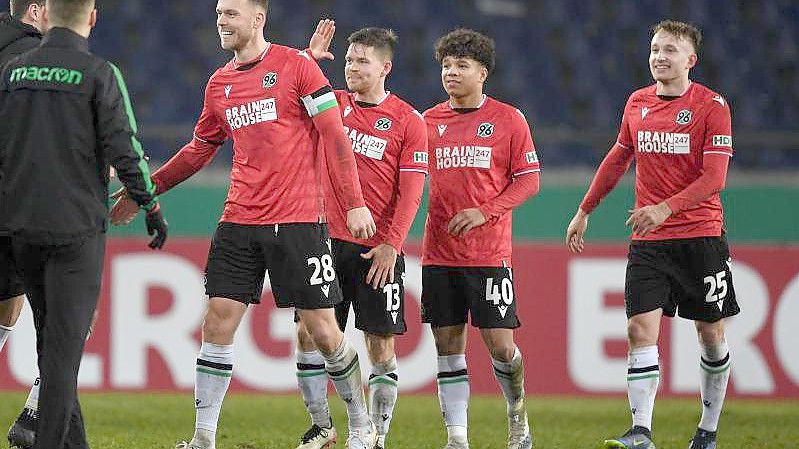 Hannovers Spieler klatschen sich nach dem Sieg gegen Mönchengladbach ab. Foto: Swen Pförtner/dpa