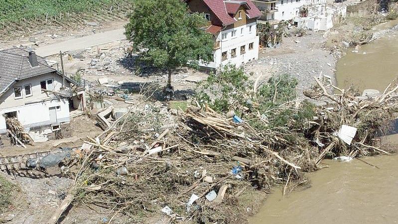 Entwurzelte Bäume liegen nach dem Unwetter neben komplett zerstörten Häusern am Ufer der Ahr in Marienthal. Foto: Boris Roessler/dpa