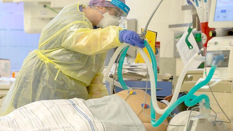 Eine Krankenschwester betreut einen Covidpatienten auf der Intensivstation des Krankenhauses Düren. (Archivbild). Foto: Thomas Banneyer/dpa