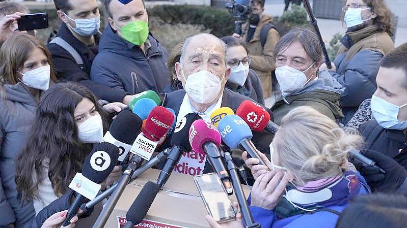 Der spanische Rentner Carlos San Juan (M) spricht mit Journalisten vor dem Wirtschaftsministerium in Madrid. Foto: Paul White/AP/dpa