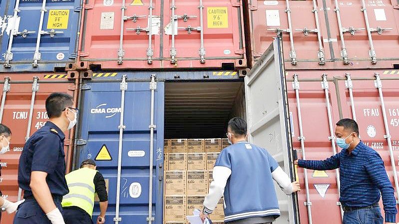 Mitarbeiter eines Frachtverteilzentrums in Xiamen kontrollieren Container vor deren Verschiffung. Foto: Wei Peiquan/XinHua/dpa