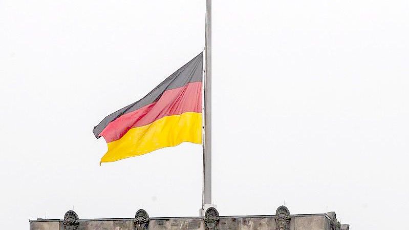 Die Deutschlandflagge auf dem Reichstagsgebäude weht auf halbmast. Foto: Christoph Soeder/dpa