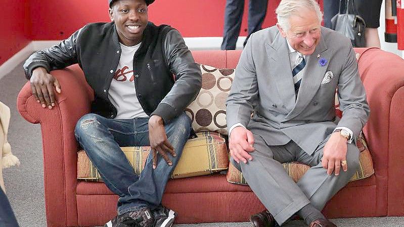 Prinz Charles (r) mit Youtuber Jamal Edwards bei der Eröffnung der Prince's Trust Summer Sessions 2013 in London. Foto: Chris Jackson/PA Wire/dpa