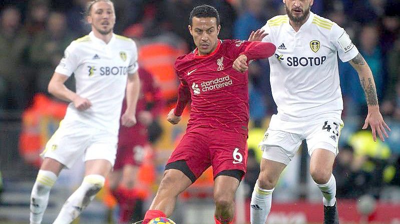 Thiago Alcantara (M) vom FC Liverpool kommt vor Sam Greenwood (r) von Leeds United an den Ball. Foto: Peter Byrne/PA Wire/dpa