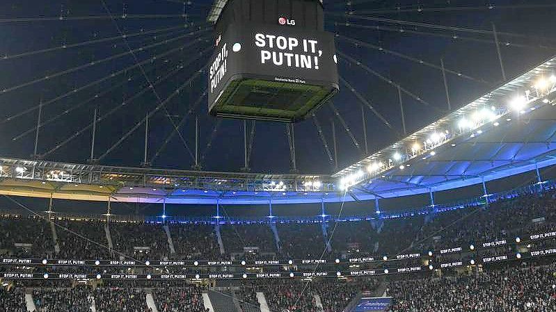 Die Mannschaften von Eintracht Frankfurt und dem FC Bayern München stehen vor dem Spiel während einer Schweigeminute für die Ukraine zusammen. Foto: Arne Dedert/dpa