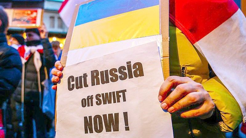 Ein Demonstrant hält ein Schild mit der ukrainischen Flagge und der Aufschrift „Russland jetzt abschneiden!“. Foto: Filip Radwanski/SOPA Images via ZUMA Press Wire/dpa