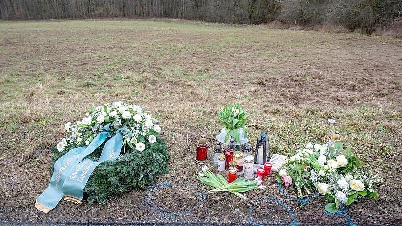 Ein Kranz sowie Blumen und Kerzen liegen am Tatort an der Kreisstraße 22 bei Ulmet (Rheinland-Pfalz) zum Gedenken. Dort wurden zwei Polizisten bei einer Verkehrskontrolle getötet. Foto: Harald Tittel/dpa