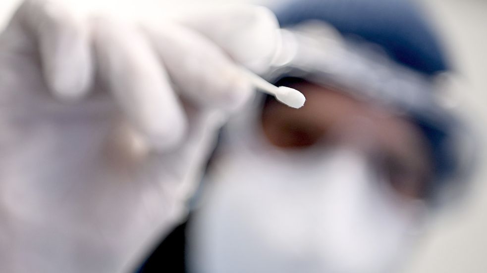 Ein Arzt hält ein Teststäbchen für die Entnahme einer Probe für einen PCR-Test in der Hand. Foto: DPA