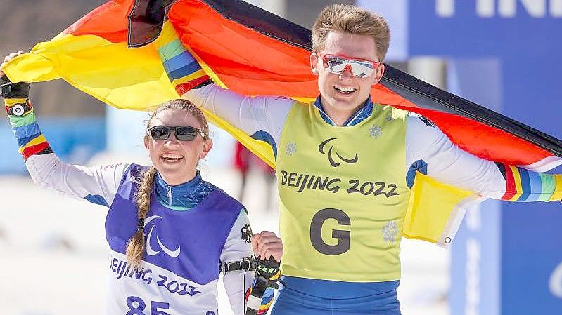 Leonie Walter und Guide Pirmin Strecker jubeln nach dem Zieleinlauf. Foto: Jens Büttner/dpa-Zentralbild/dpa