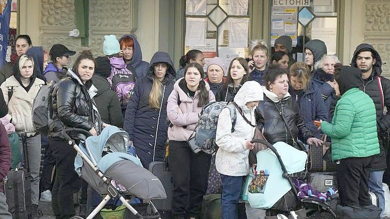 Flüchtlinge mit Kindern warten auf einem Bahnhof im polnischen Przemysl auf einen Transport. Foto: Sergei Grits/AP/dpa