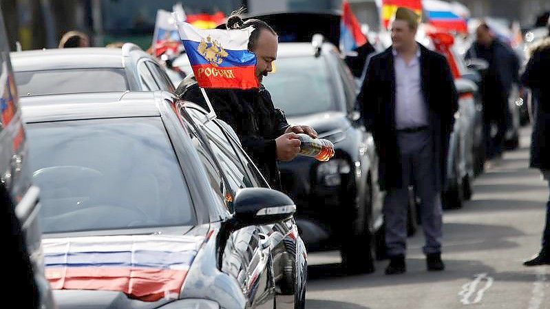 Russische Flaggen wehen an Autos vor dem Berliner Olympiastadion. Foto: Carsten Koall/dpa