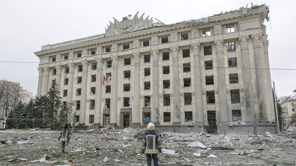 Ukrainische Rettungskräfte stehen vor dem beschädigten Rathausgebäude in Charkiw nach dem russischen Beschuss. Foto: DPA