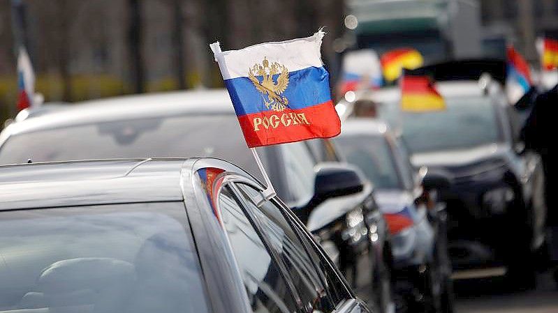 Russische Flaggen wehen an einem Auto vor dem Berliner Olympiastadion. Mit Blick auf pro-russische Demonstrationen fordern Innenpolitiker ein striktes Durchgreifen der Polizei bei Verstößen gegen Auflagen oder Gesetze. Foto: Carsten Koall/dpa