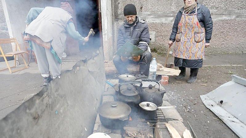 Einwohner kochen in Mariupol im Freien. Foto: Victor/XinHua/dpa