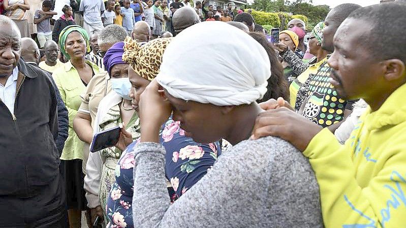 Der südafrikanische Präsident Cyril Ramaphosa spricht in dem Ort Durban mit trauernden Familienmitgliedern. Foto: Kopano Tlape/South African Communications and Information Services/AP/dpa