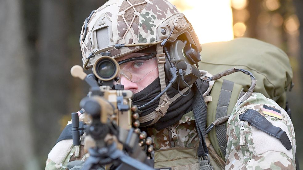 Ein Kampfschwimmer der Kommando Spezialkräfte der Marine (KSM) zielt bei einer Einsatzübung auf einem Truppenübungsplatz mit dem Maschinengewehr MG5. Foto: DPA