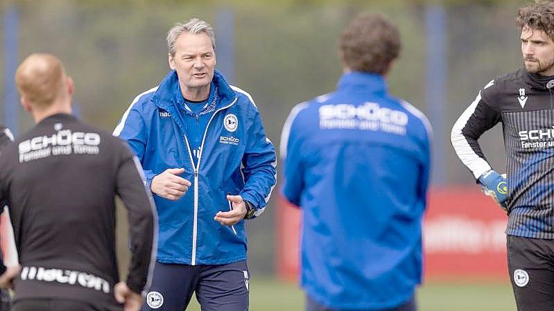 Der bisherige Torwarttrainer Marco Kostmann (2.v.l) spricht als Hauptverantwortlicher beim Training von Arminia Bielefeld. Foto: Friso Gentsch/dpa