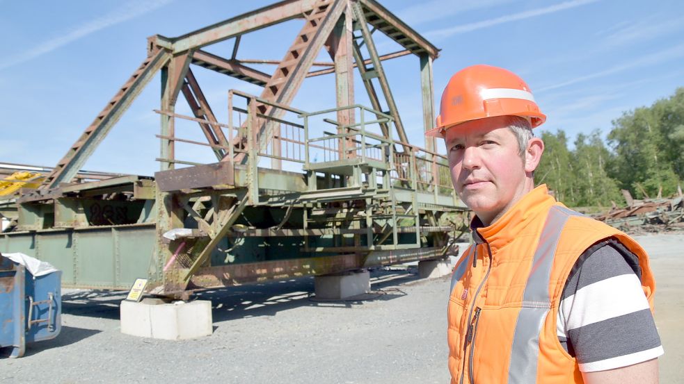 Diplom-Ingenieur Stefan Schwede, Teilprojektleiter Friesenbrücke bei der Deutschen Bahn, steht vor einem der Brückenteile, die auf dem Gelände der Firma EFG Port Papenburg im Papenburger Hafenbereich zerkleinert werden. Foto: Ammermann