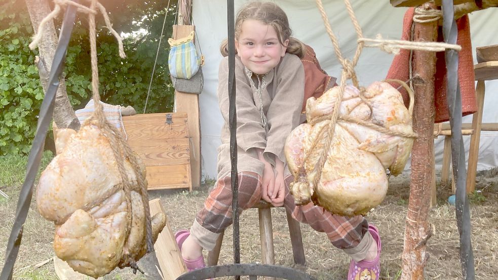 Die siebenjährige Molly hat ein Auge auf die Hähnchen über dem Grill. Foto: Neelke Harms