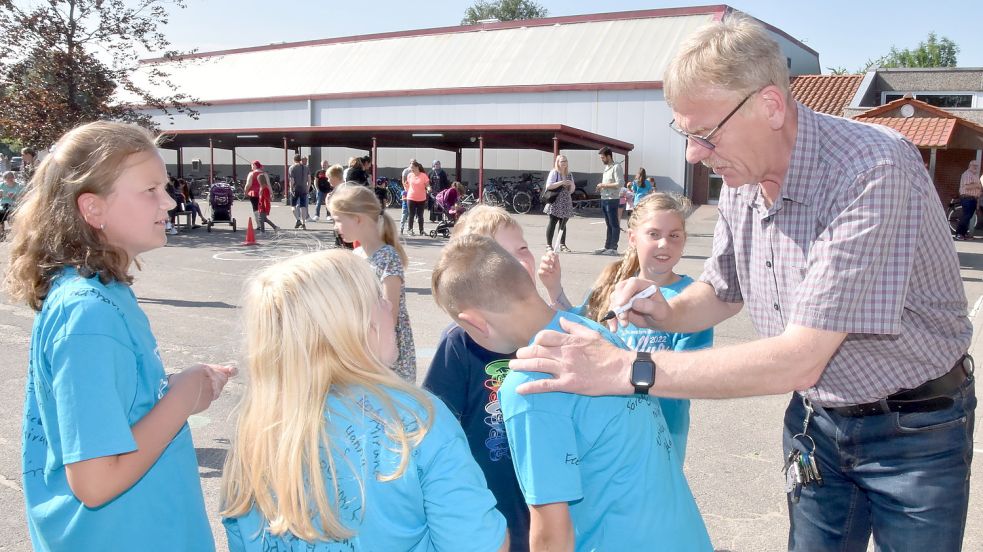 Autogramm vom Schulleiter: Geduldig signierte Werner Knippelmeyer die Abschiedsshirts der gemeinsam mit ihm verabschiedeten Viertklässler. Foto: Thomas Dirks