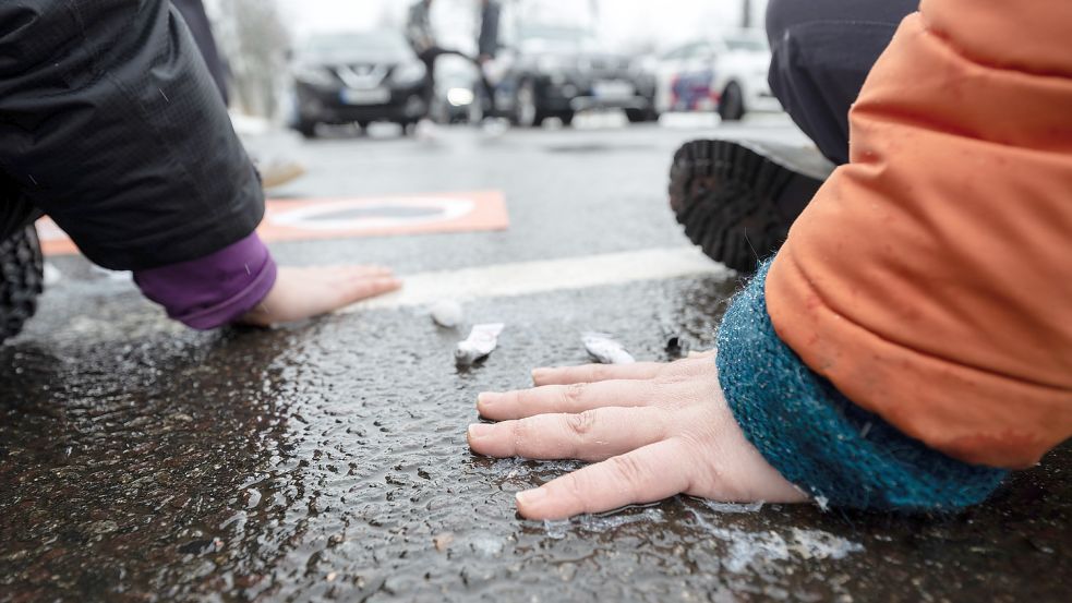 Mit Sekundenkleber haben sich zwei Aktivistinnen der Letzten Generation auf einer Fahrbahn in Leipzig festgeklebt. Foto: dpa/Hendrik Schmidt